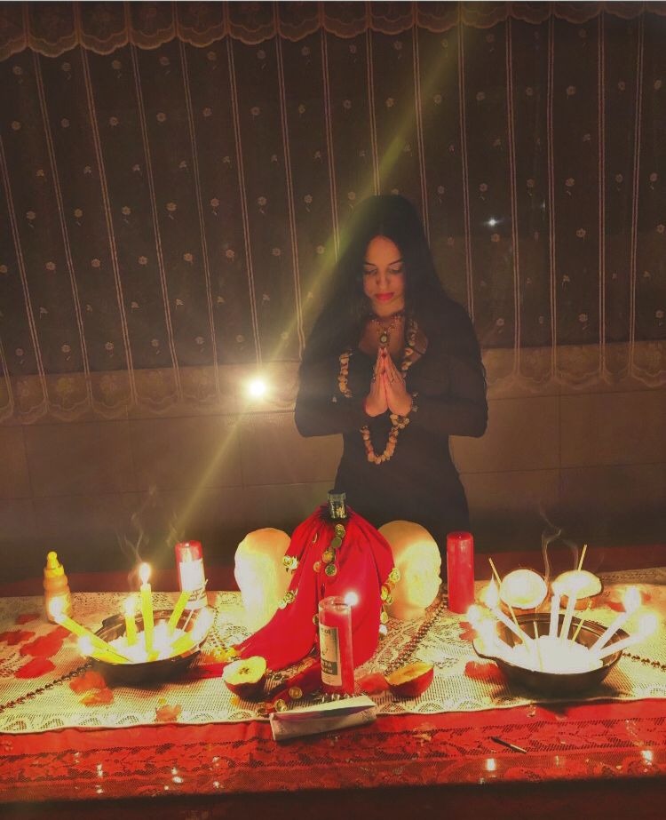 Taróloga Pamela em sua mesa de leitura com cartas e velas