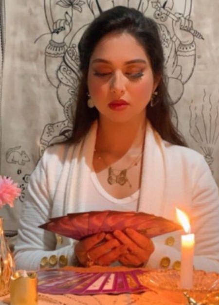 Taróloga Pamela em consulta segurando as cartas de tarot, à luz de velas